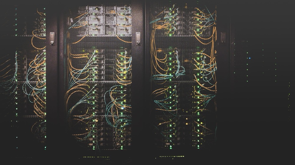 Two server racks filled with dense bundles of colored network cabling