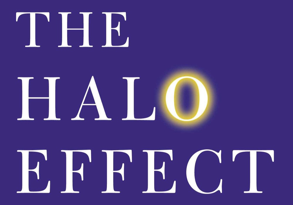 The cover of the book The Halo Effect, white lettering on purple with a glowing ring around one letter