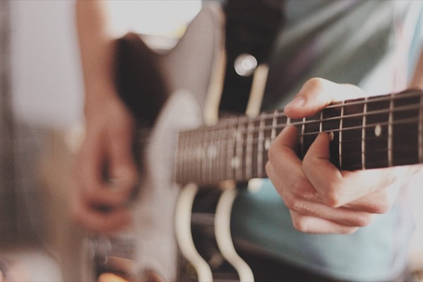 Close-up of a person's hands playing an electric guitar